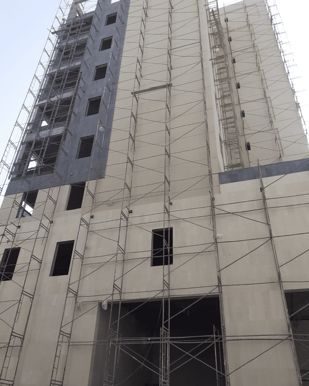 مبنى قيد الإنشاء بسقالات وواجهة حجر أبيض