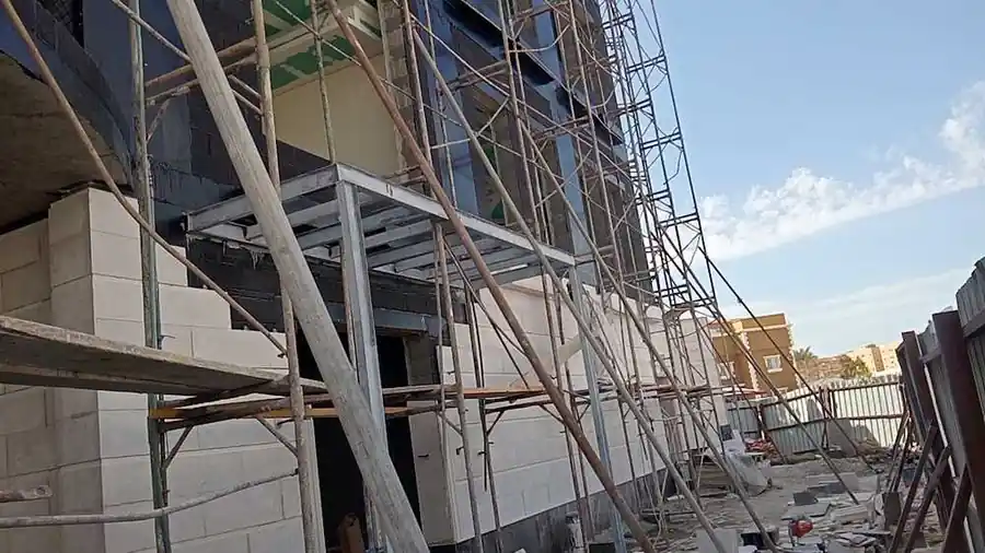 تركيب حجر الرياض الأبيض أثناء تنفيذ عمارة سكنية في جدة
